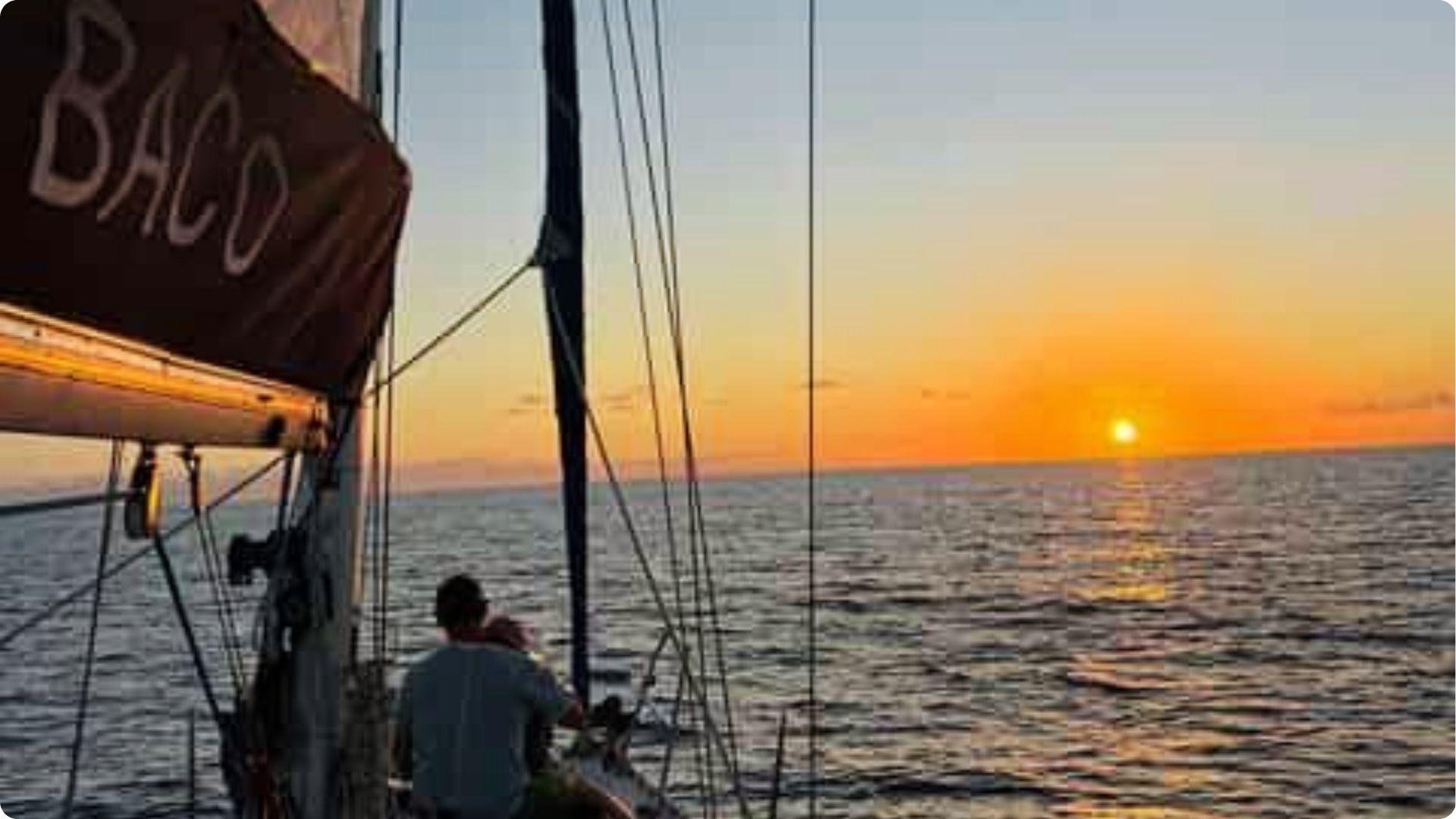 Couple enjoying romantic sunset sailboat cruise over calm ocean waters in Myrtle Beach, SC getaway