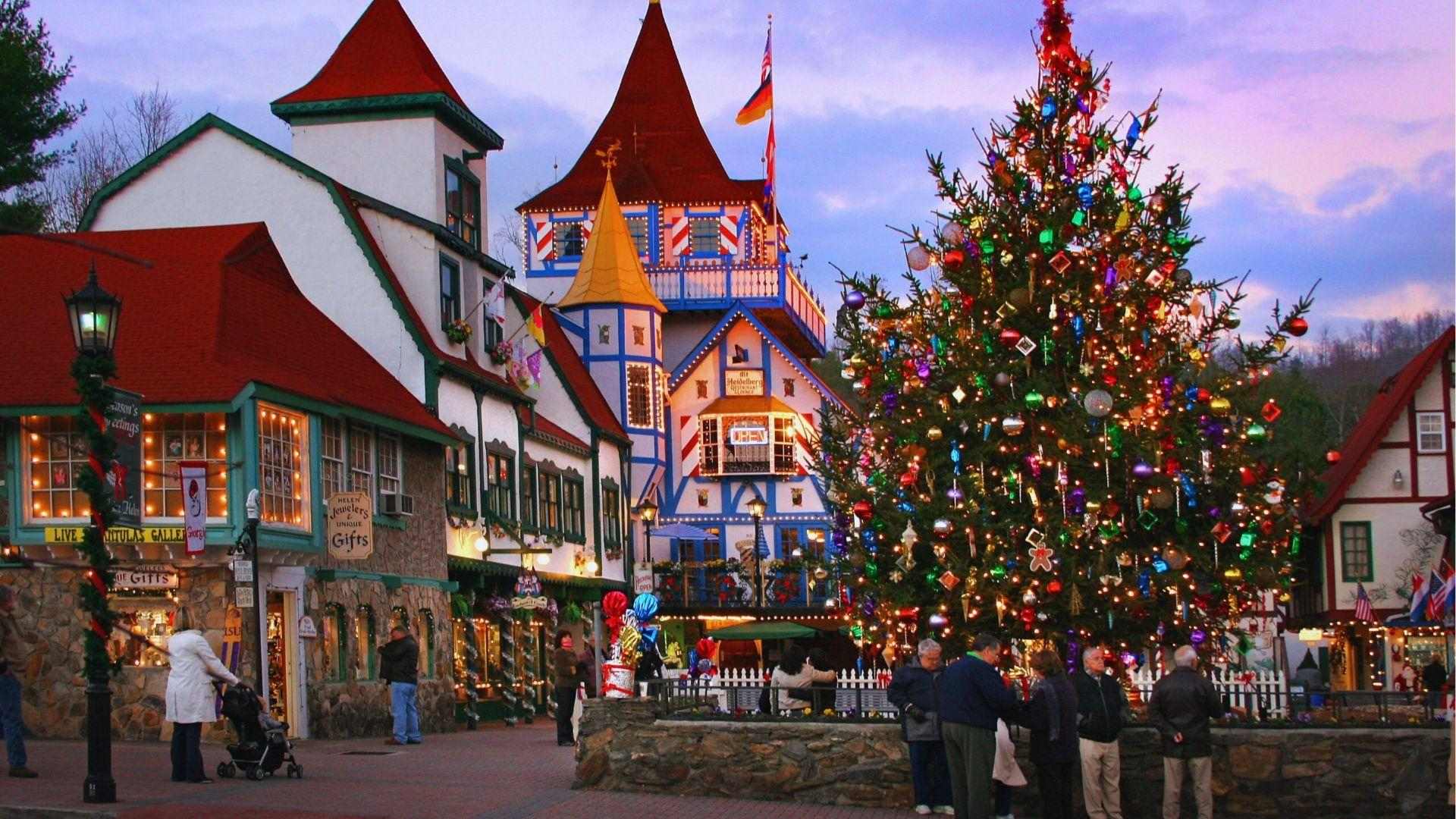 Christmas tree with colorful ornaments in Helen village square surrounded by Bavarian shops and visitors.