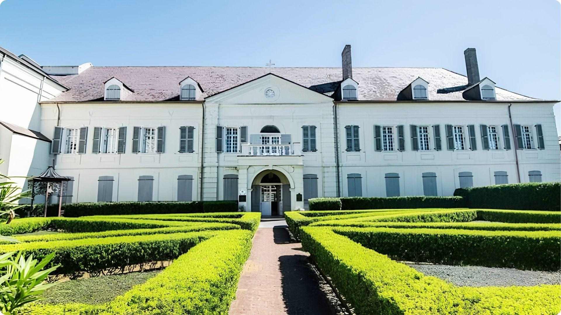 Old Ursuline Convent Museum with manicured hedge gardens, oldest building tour in New Orleans French Quarter