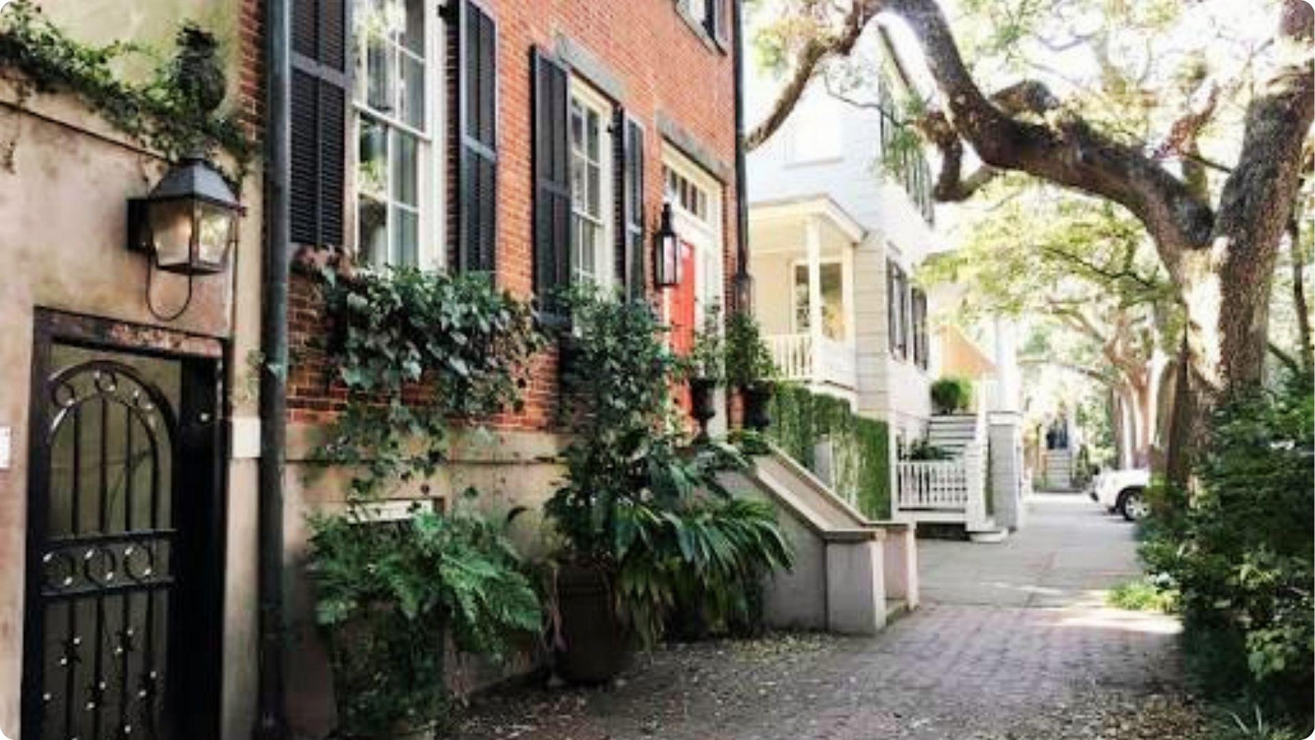 Charming brick townhouses with black shutters and ivy on Jones Street Savannah walking tour.