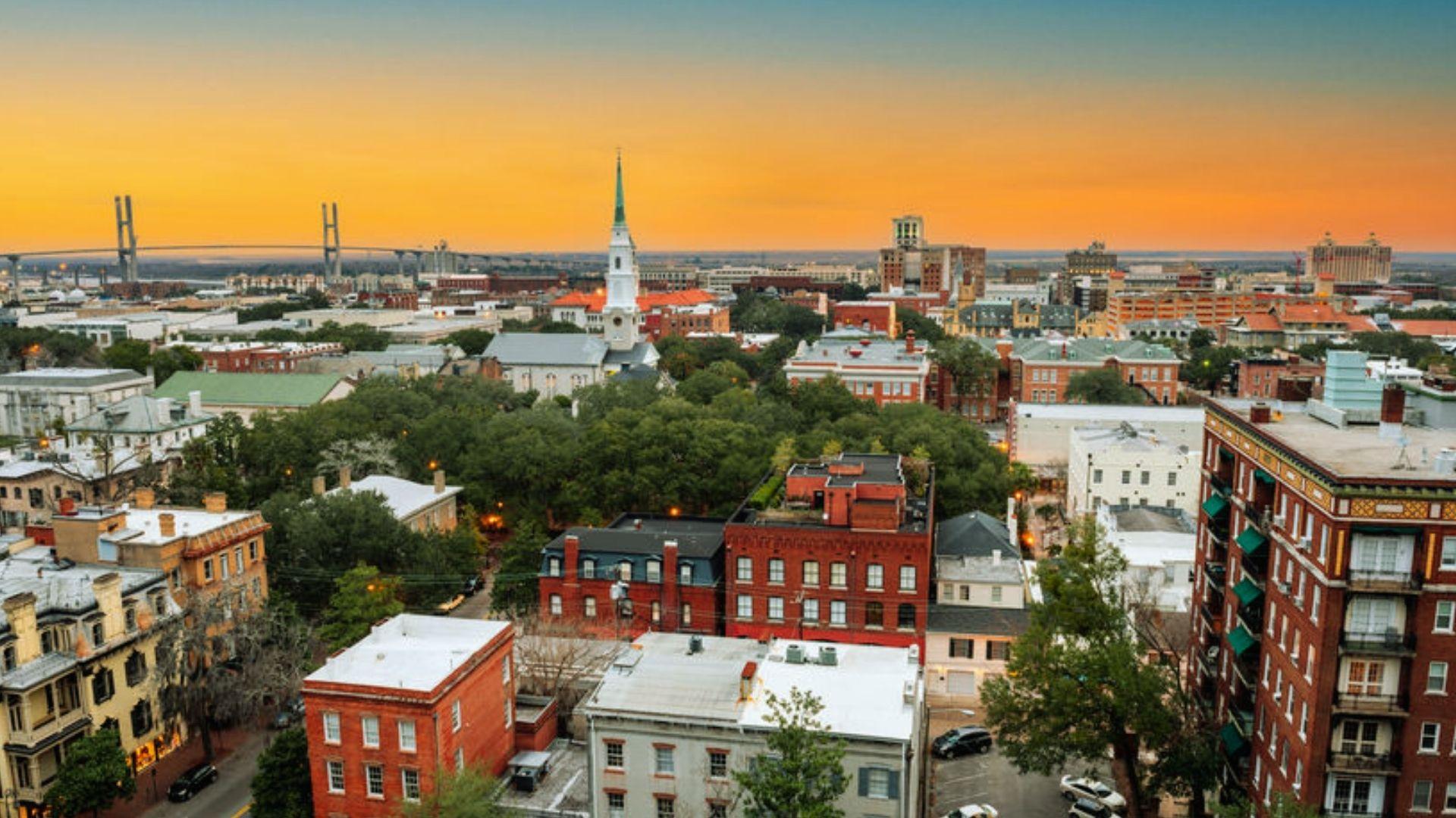 Aerial view of Savannah historic district at sunset with church steeple and Talmadge Bridge