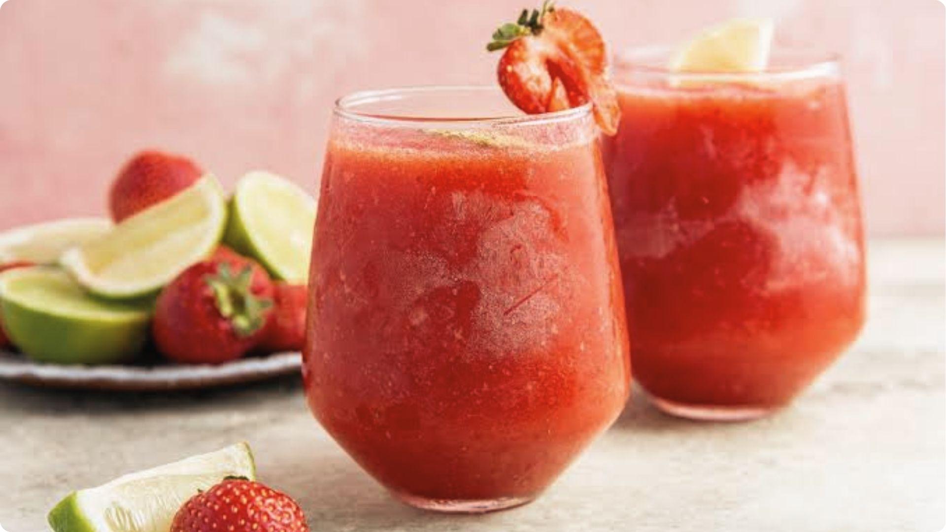 Frozen New Orleans strawberry daiquiri cocktails with lime and fresh strawberries, refreshing French Quarter drink.