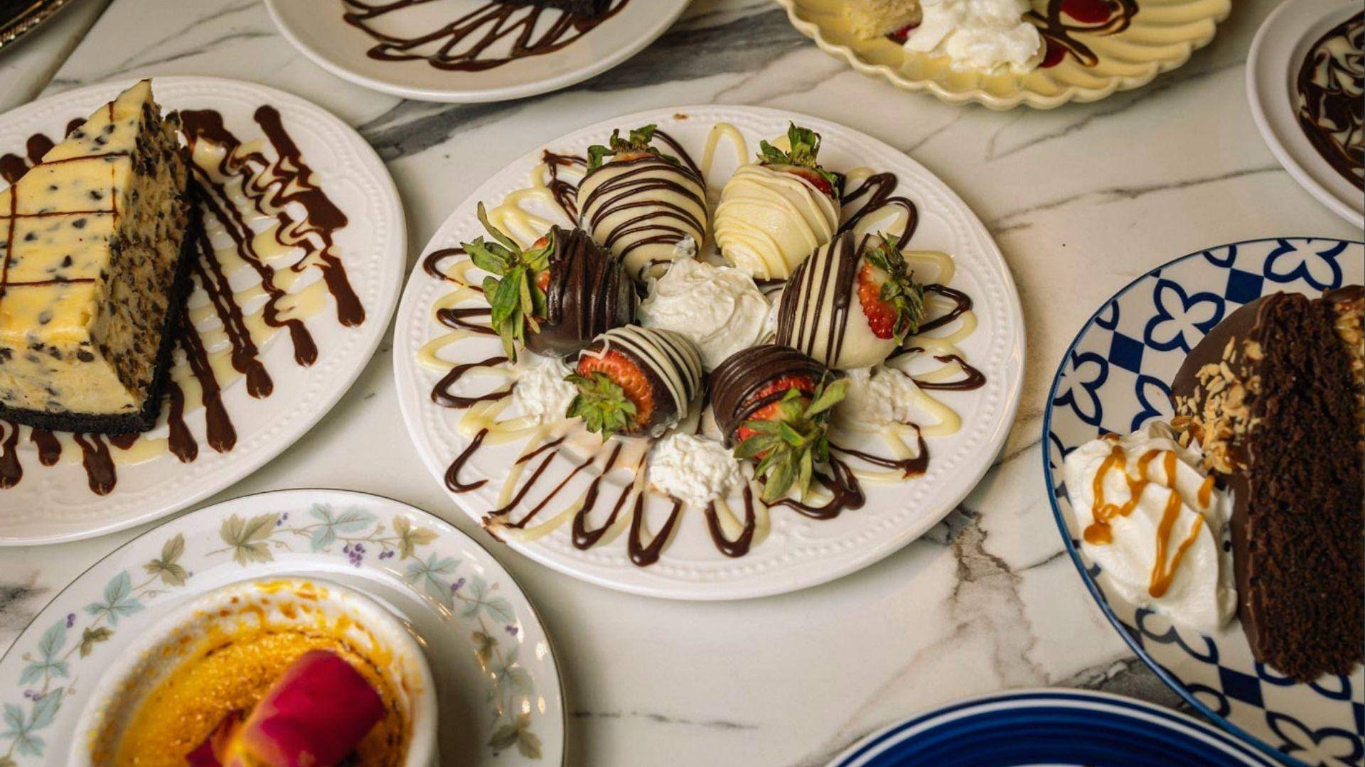Dessert plates with chocolate-covered strawberries, cheesecake, chocolate cake and creme brulee