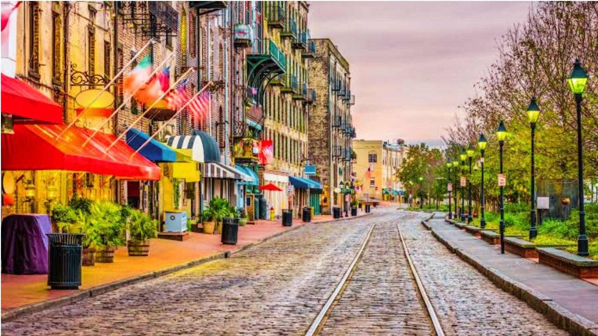 Charming cobblestone street in Savannah with colorful storefronts and lampposts