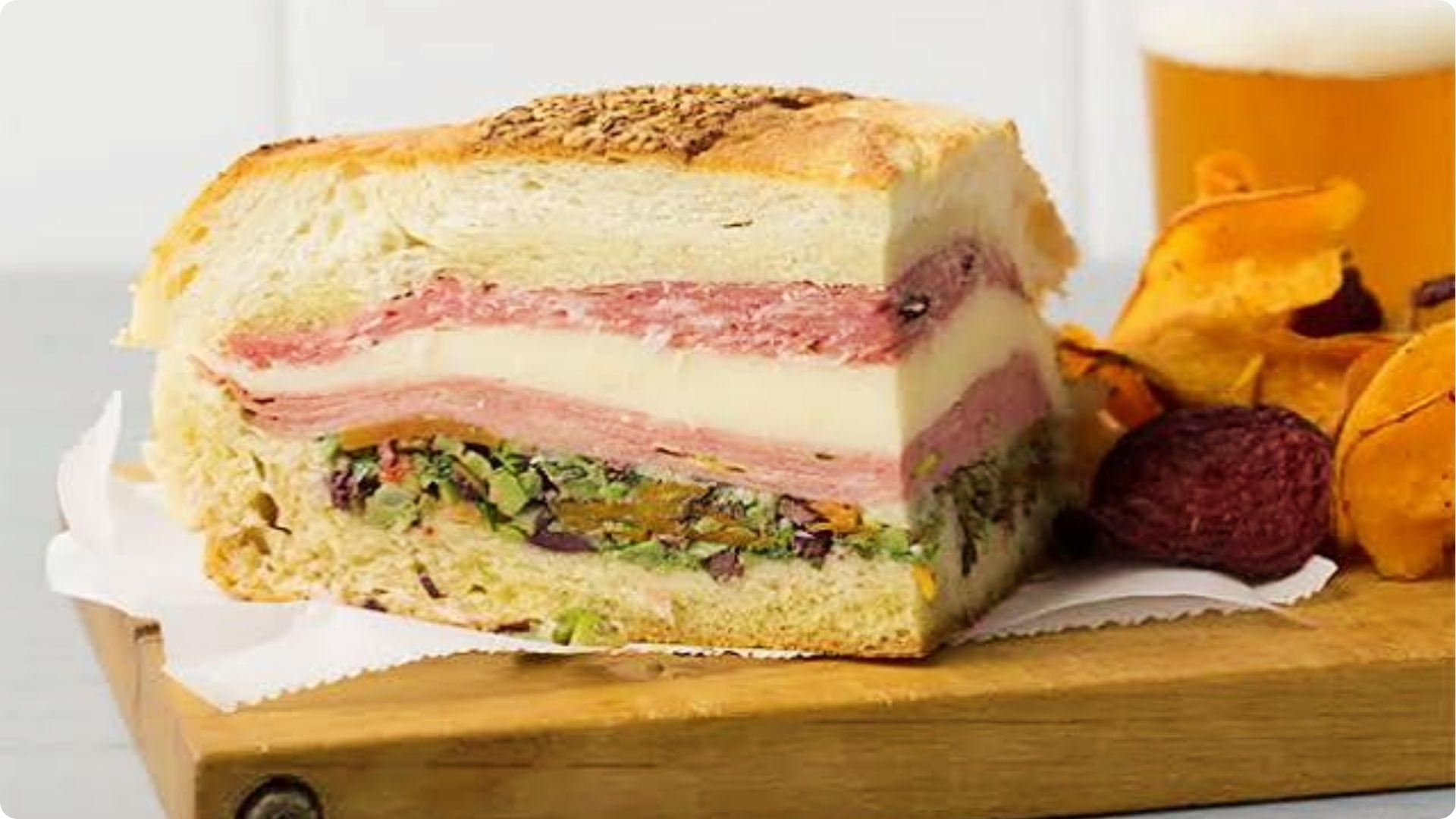 Classic muffaletta sandwich with layered meats and olive salad, must-try food in French Quarter delisThe muffuletta is a New Orleans original that deserves its own mention.
