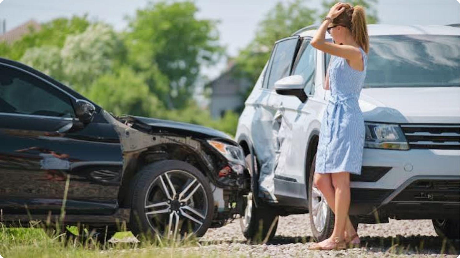 Distressed woman by crashed cars after accident, confused about Georgia no-fault insurance laws.