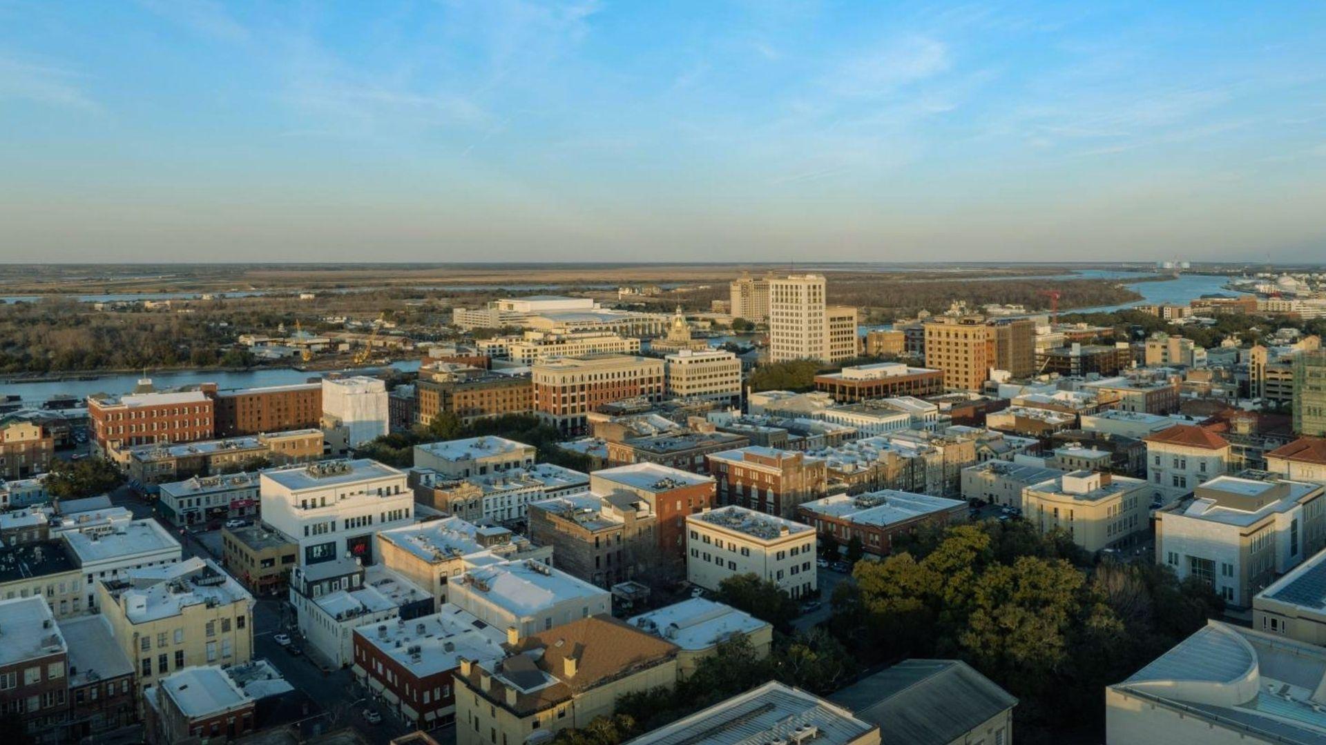 Aerial view of Savannah historic district with river, marshlands and downtown buildings in sunlight