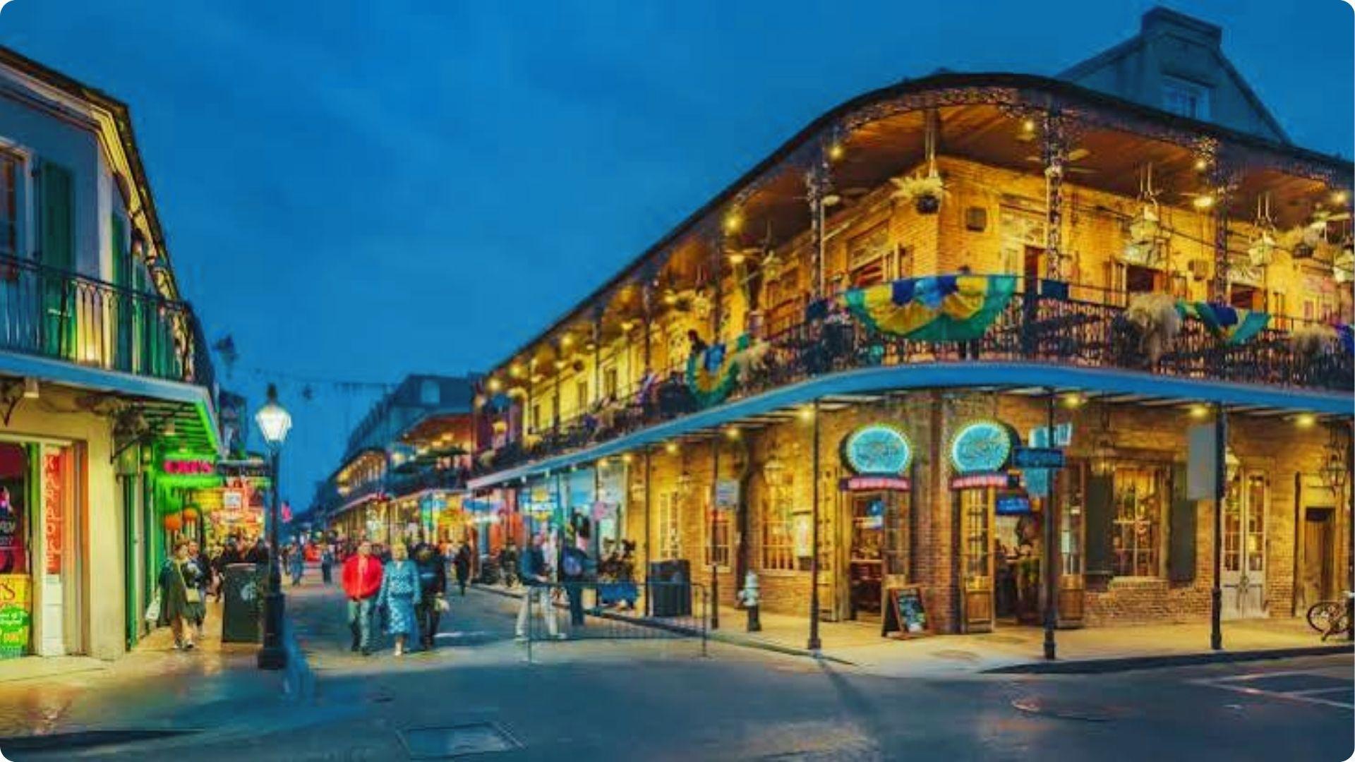 Vibrant Bourbon Street at dusk with glowing balconies and Mardi Gras flags, top nightlife stroll in French Quarter
