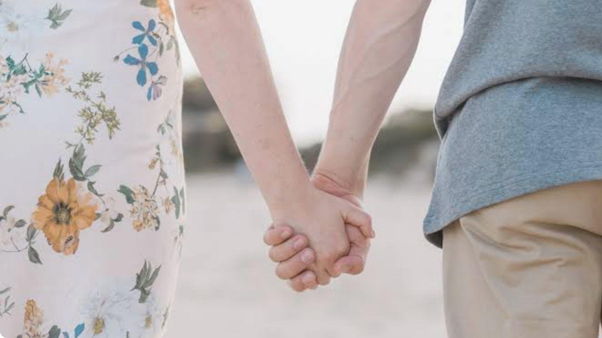 Couple holding hands while walking together outdoors