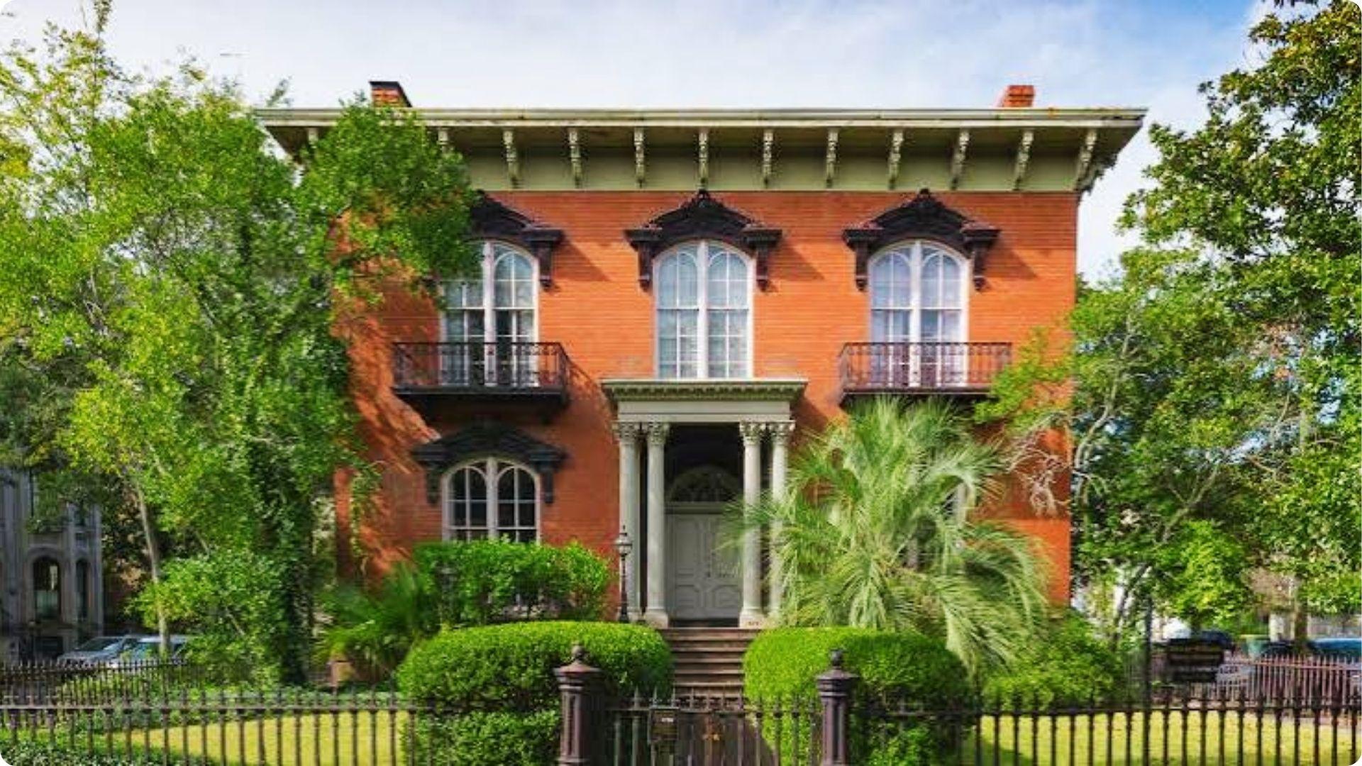 Historic red brick Mercer Williams House with iron balconies on Savannah walking tour map stop.