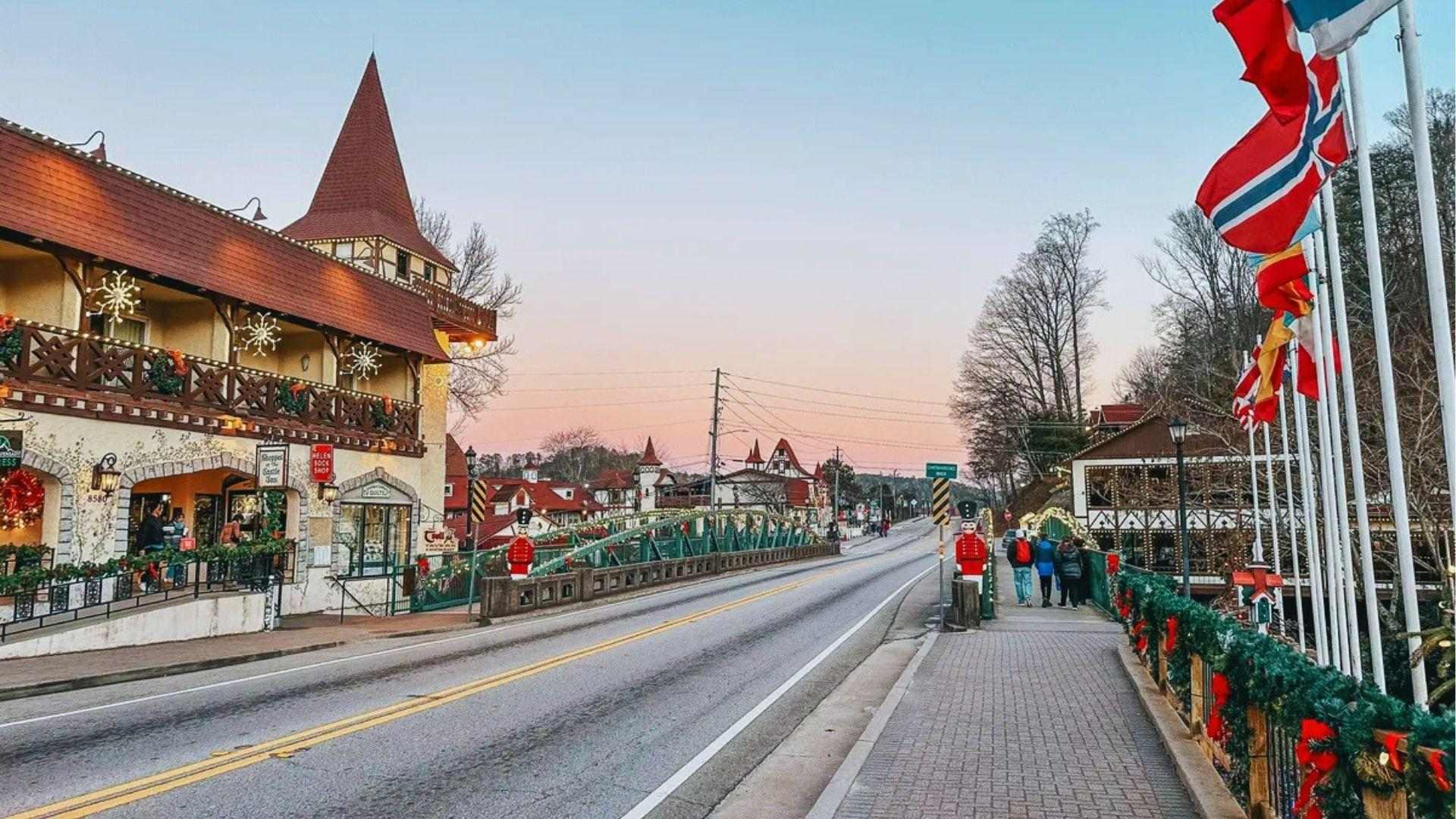 Helen Georgia street decorated for Christmas with garlands, nutcrackers flags and Bavarian buildings at dusk.