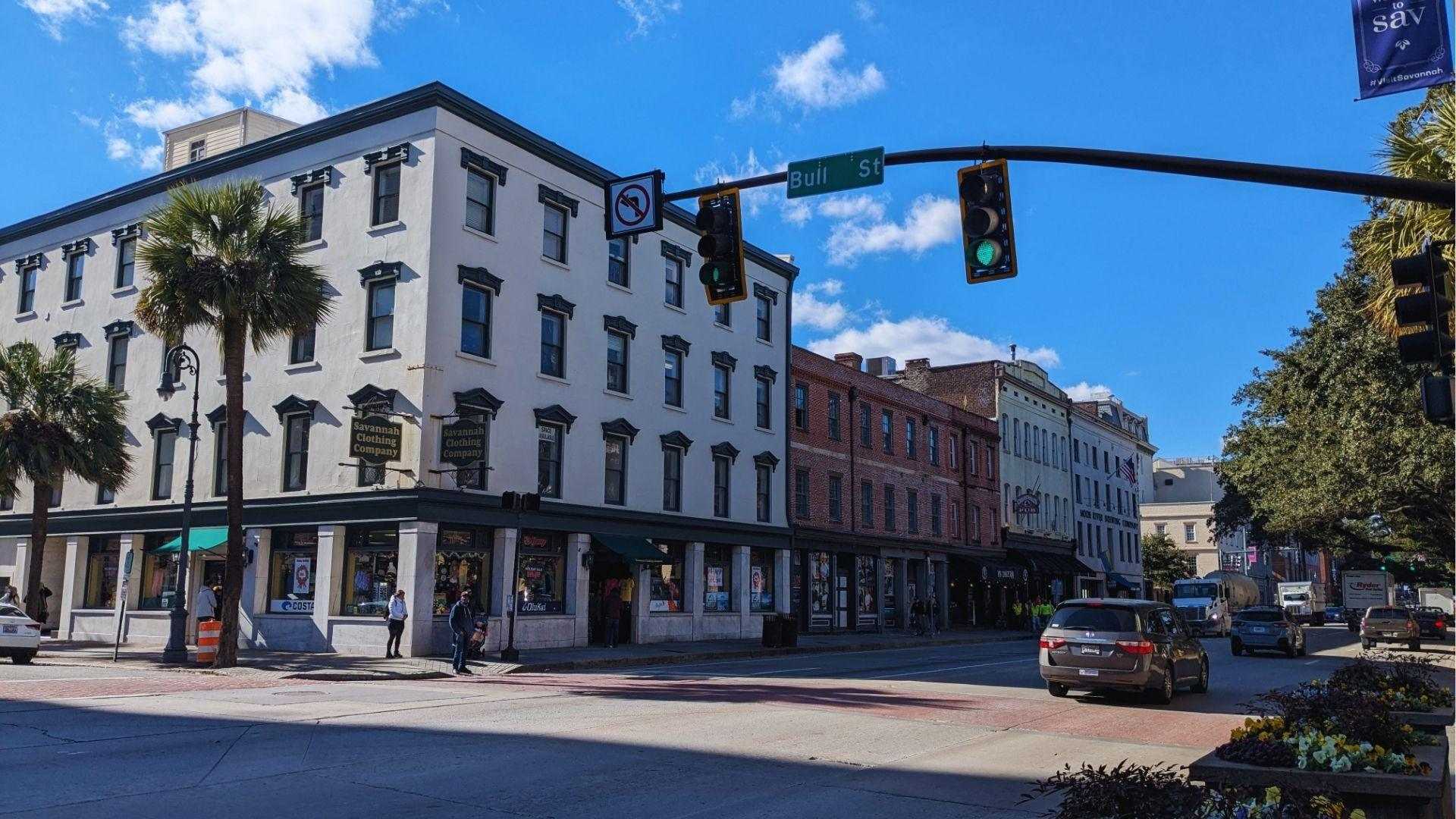 White Savannah Clothing Company building at east bay street with palm trees and traffic lights.
