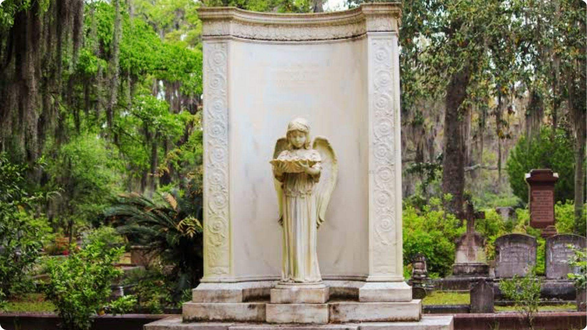 Historic angel statue monument in Bonaventure Cemetery surrounded by oak trees in Savannah Georgia