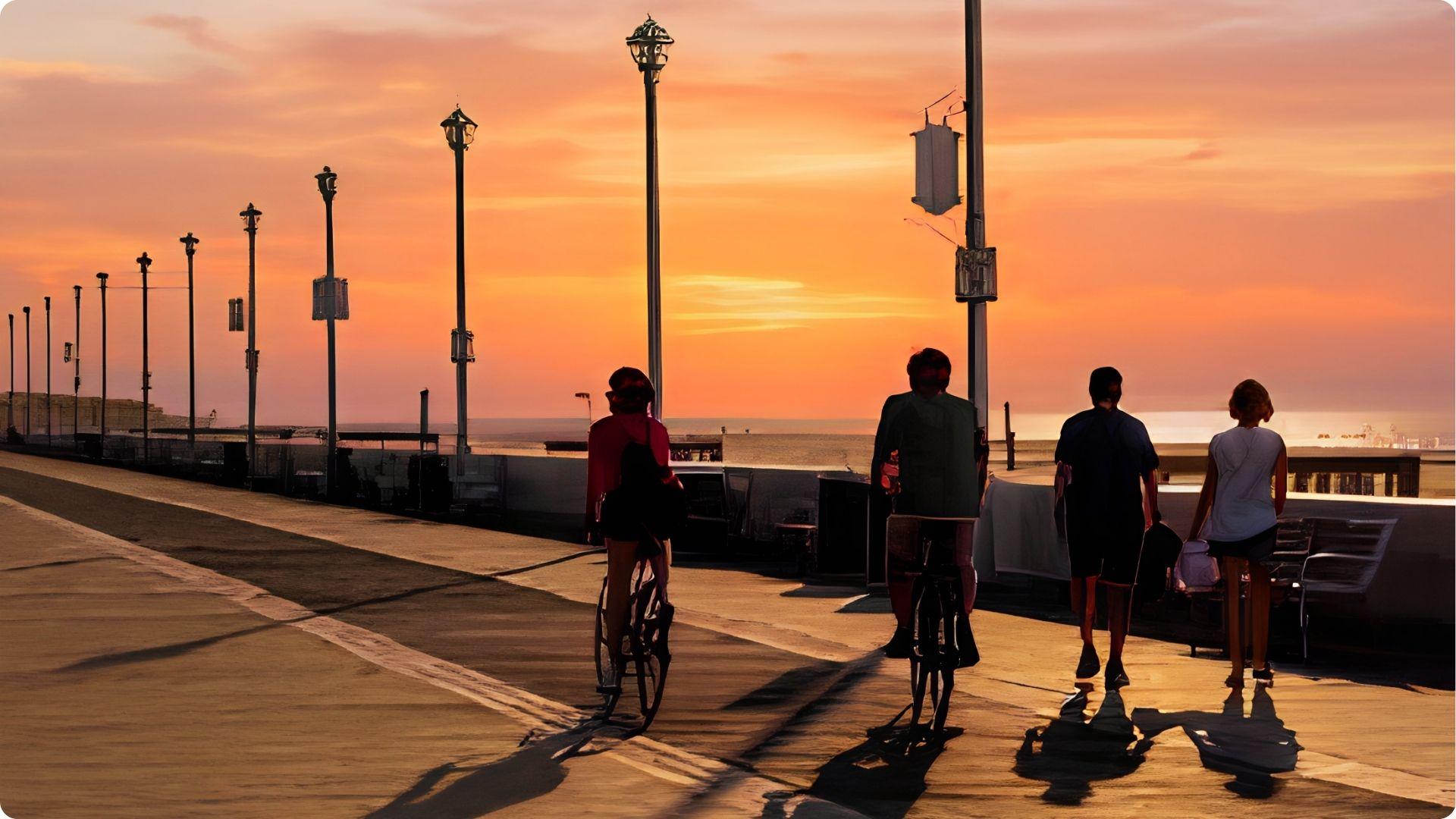 Couples biking and walking on Myrtle Beach boardwalk at vibrant orange sunset, romantic evening stroll