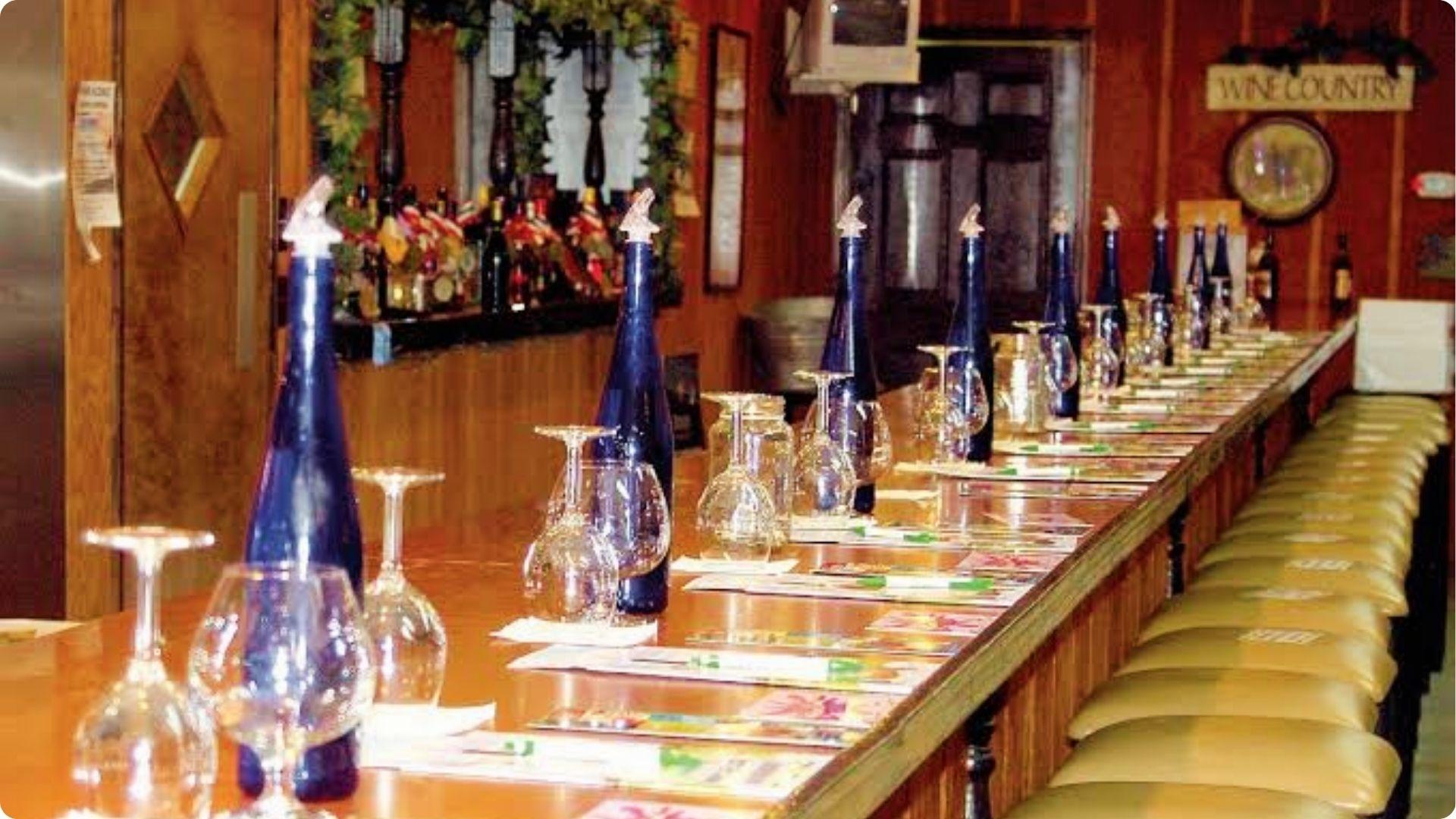 Wine tasting bar setup with blue bottles and glasses lined up for couples at Myrtle Beach winery