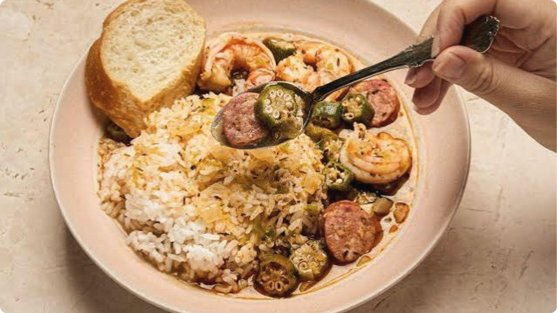 Steaming New Orleans gumbo bowl with shrimp, andouille, okra, rice and crusty bread on the side.