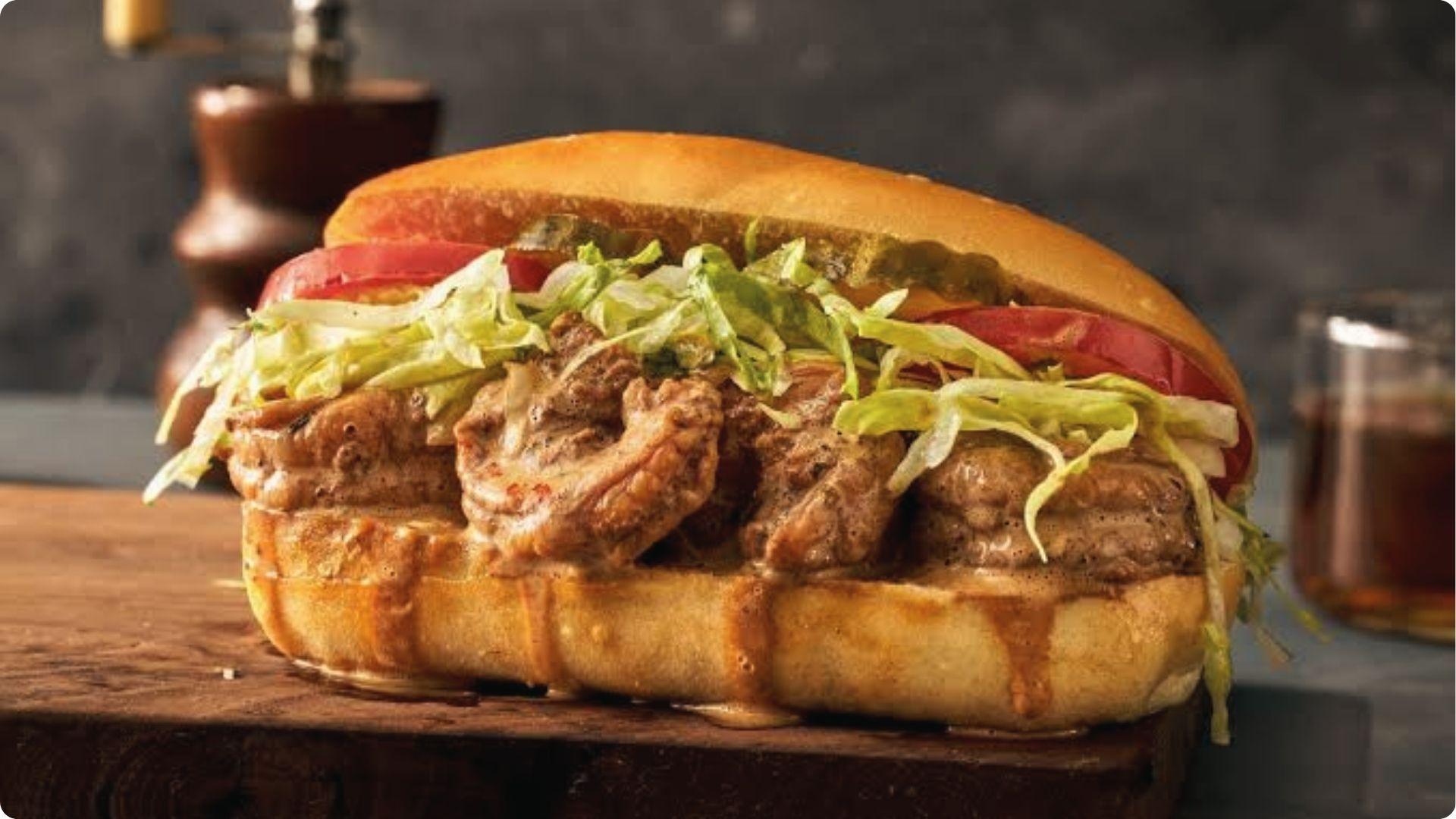 Crispy fried shrimp po'boy sandwich with lettuce, tomato, remoulade on toasted French bread roll.