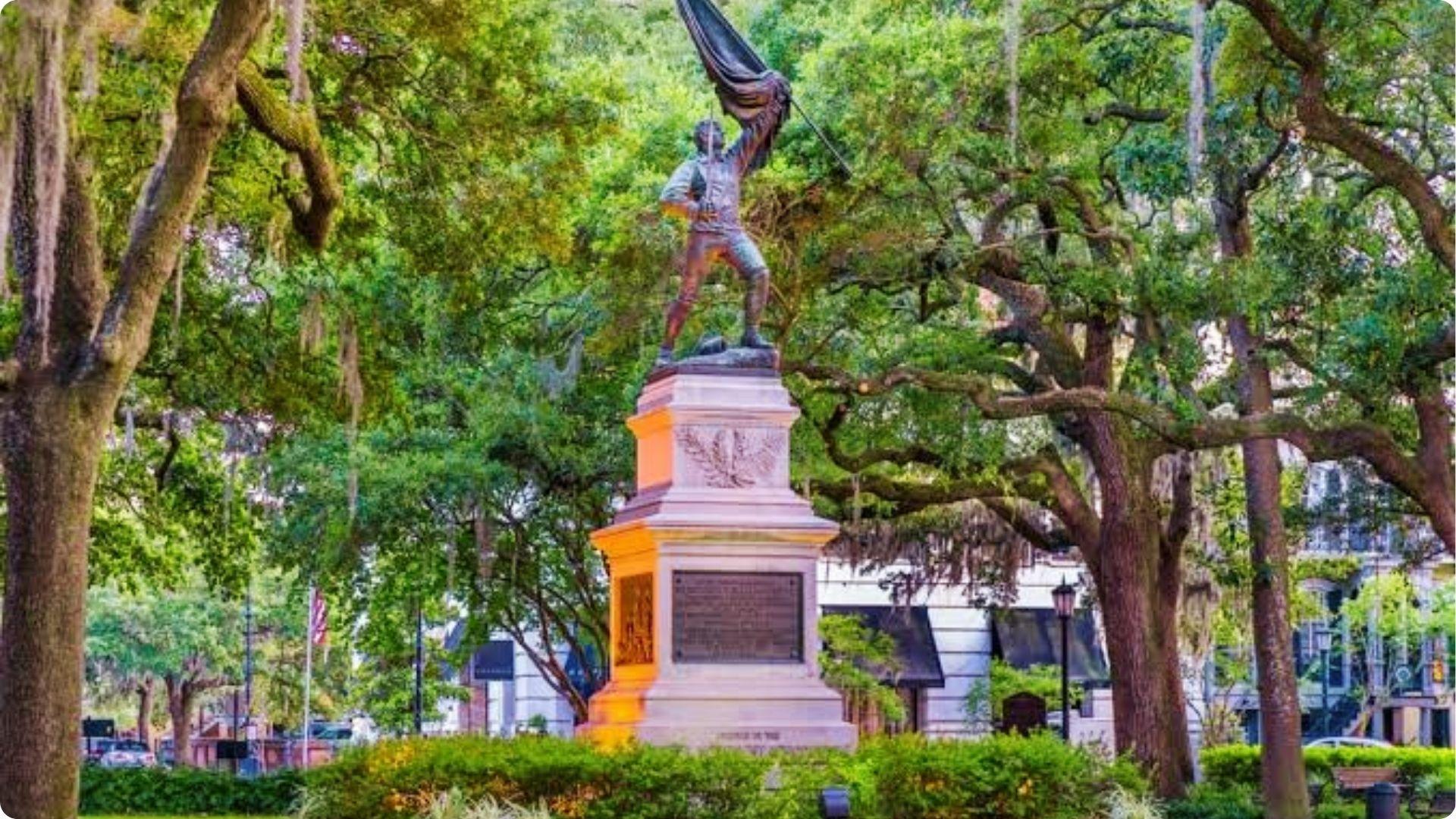 Sergeant Jasper statue holding flag under moss-draped oaks in historic Savannah walking tour square.