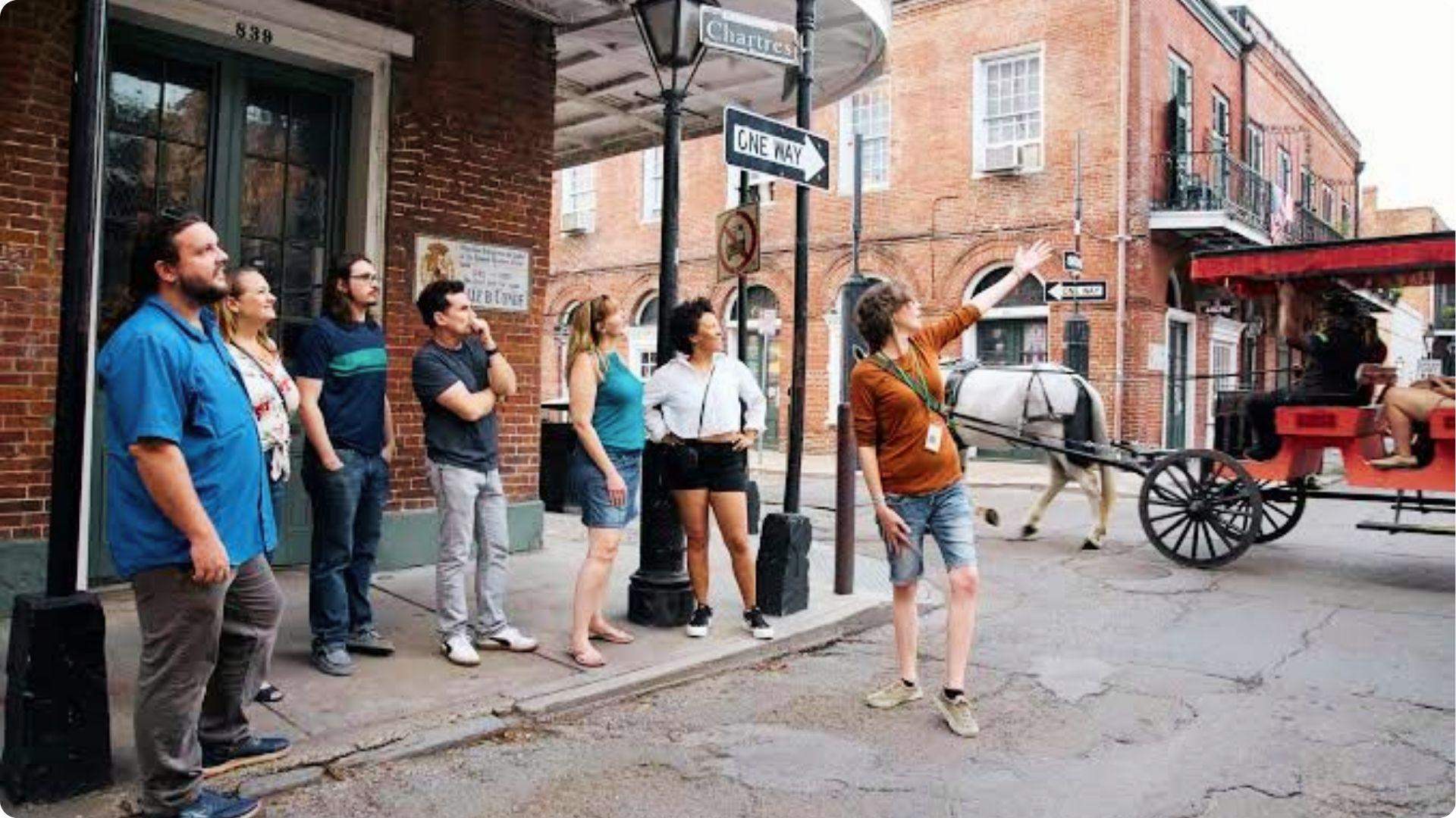 Guided walking tour group on Chartres Street with carriage, top historical tour activity in French Quarter