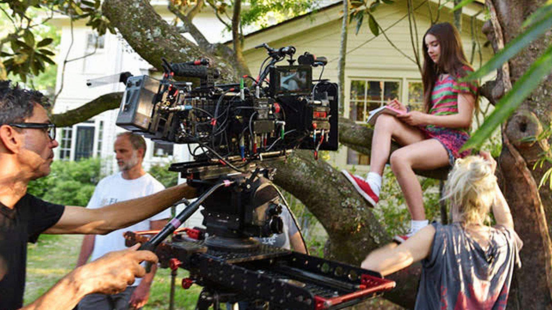 Film crew shooting movie scene with actress in tree in Savannah GA backyard