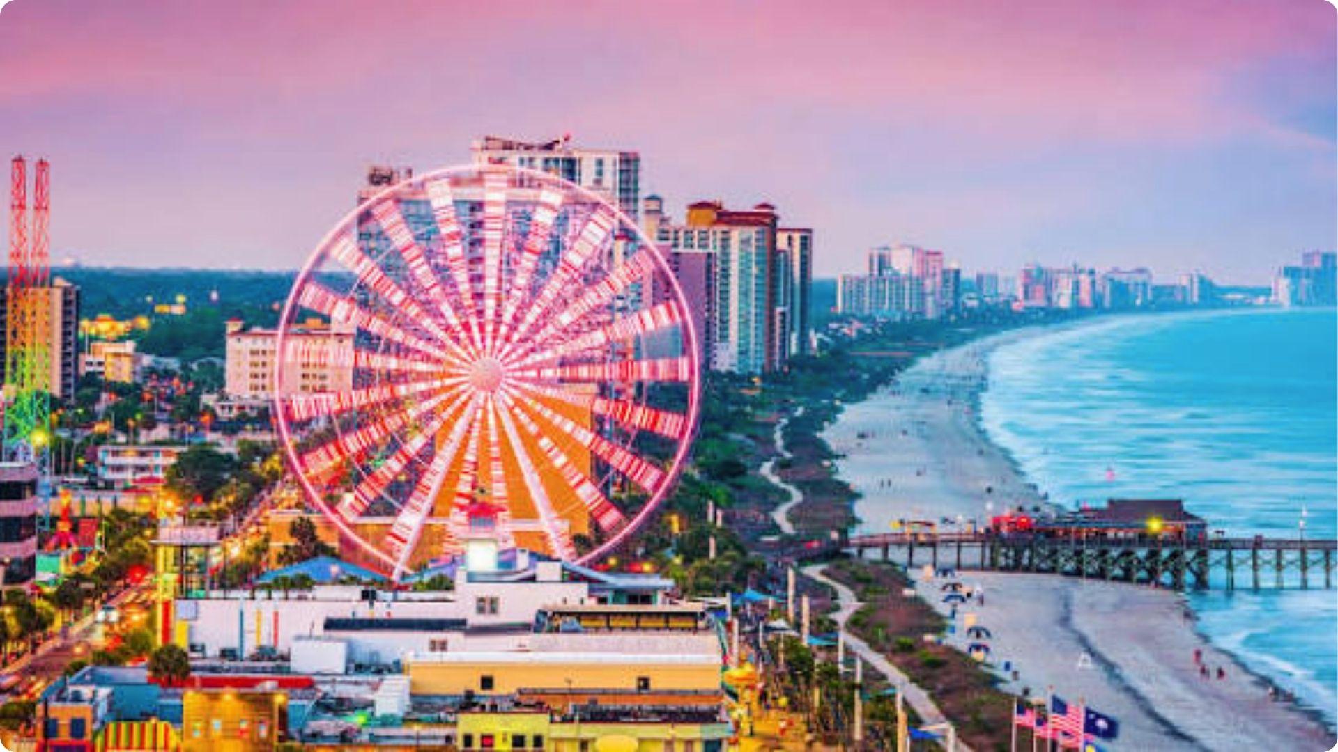 Illuminated Ferris wheel glowing over Myrtle Beach boardwalk and beachfront at twilight for couples