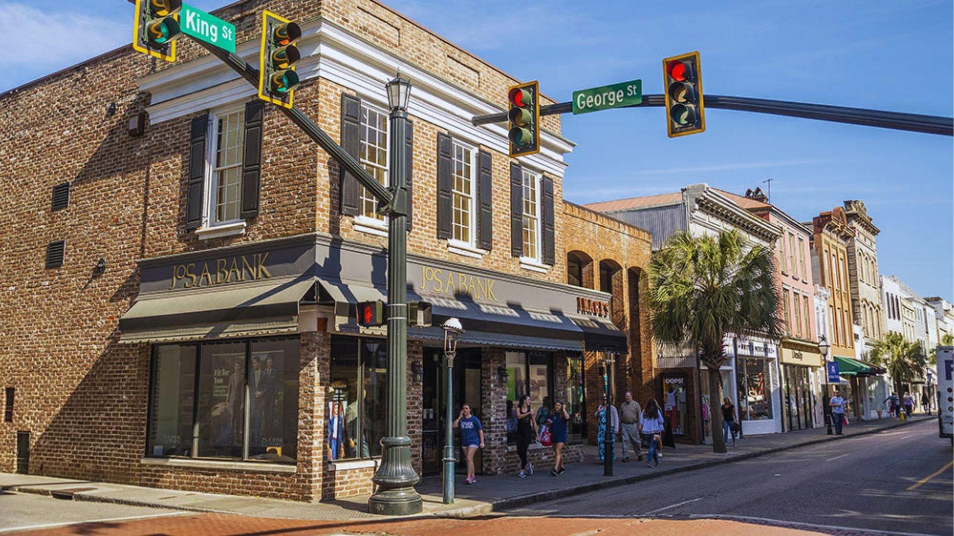 Housing Jos A Bank at King and George Streets Charleston with pedestrians and palm trees.