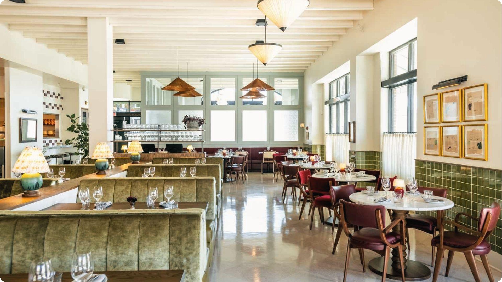 Bright modern Atlanta bistro with olive velvet booths, marble tables, brass lamps and tall windows