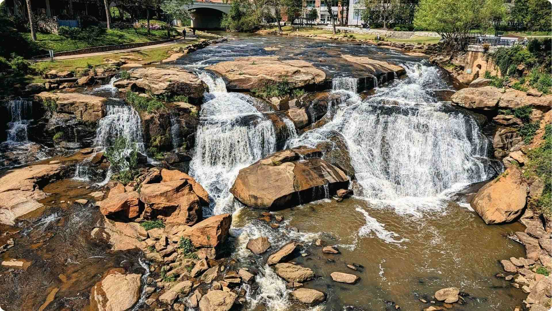Falls Park waterfall in Greenville cascading over rocks, picturesque water-filled day trip from Atlanta.