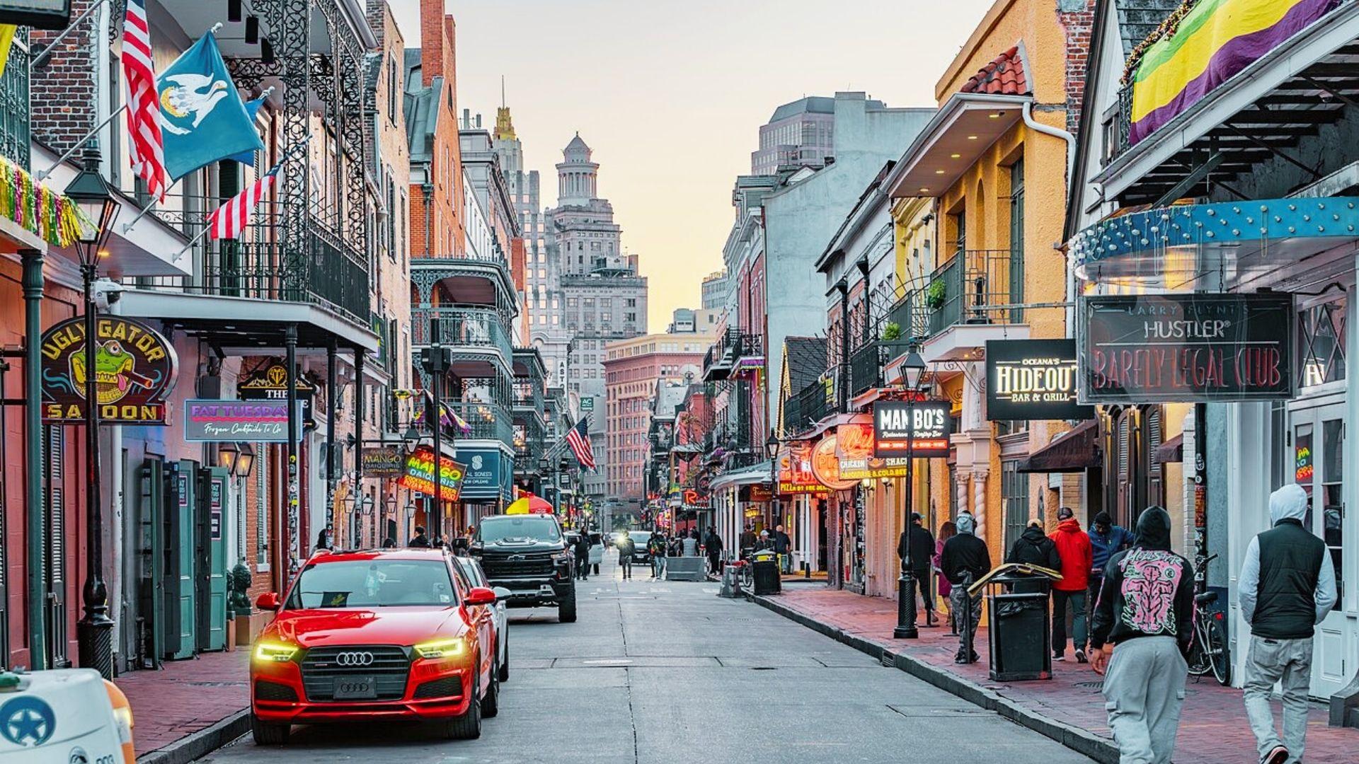 A vibrant New Orleans street with pedestrians and vehicles, illustrating the dynamic life of the city.