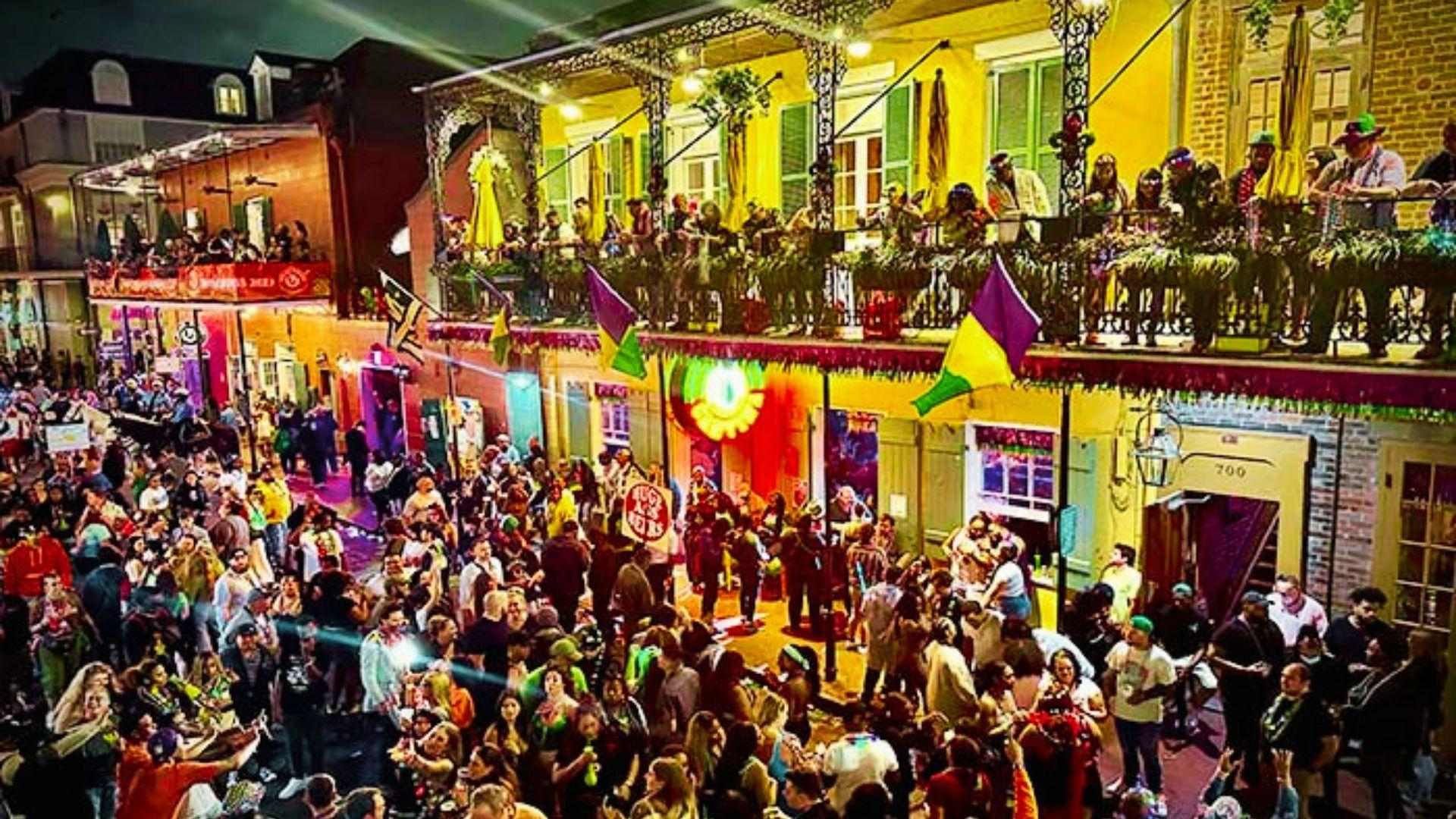 Mardi Gras parade floats rolling down a New Orleans street at night with crowds cheering on the sidelines.