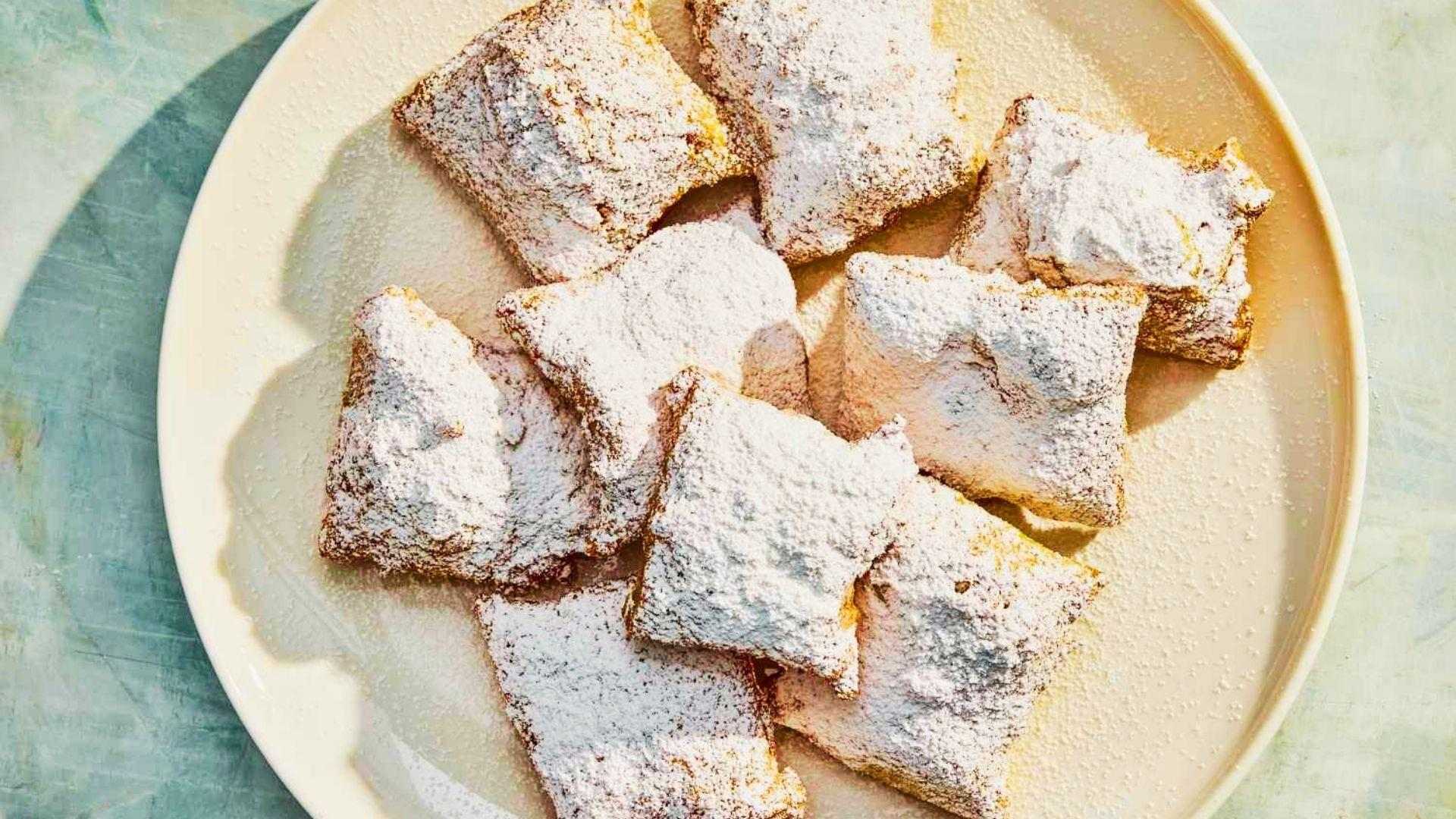 fresh beignets dusted with a thick layer of powdered sugar.