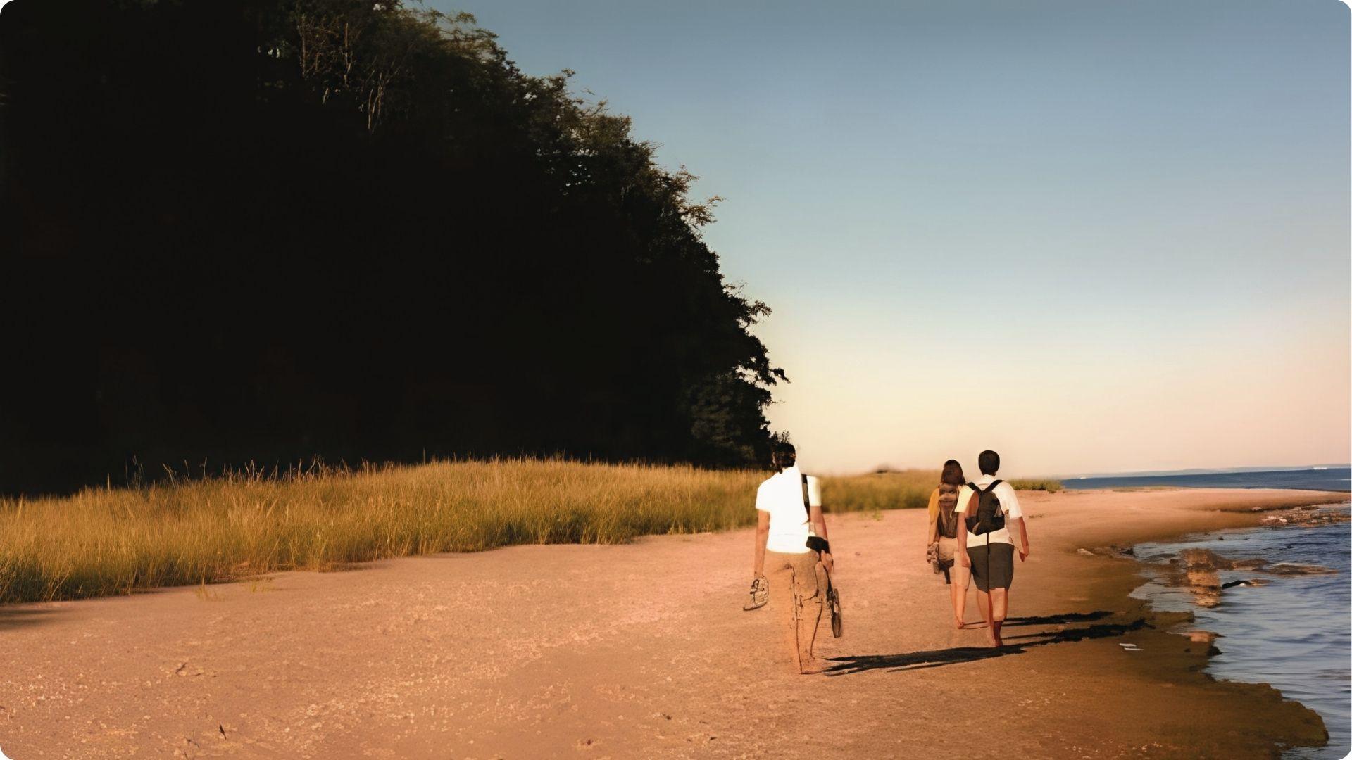 Three friends walking barefoot on a sandy path at East Beach St Simons with dunes and calm shoreline.
